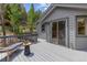 Wood deck outside of home with wood railings and a table and chair set at 6882 Snowshoe Trl, Evergreen, CO 80439
