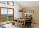 Dining area featuring a wood table set, modern lighting, and sliding glass doors to the balcony at 6882 Snowshoe Trl, Evergreen, CO 80439
