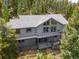 Exterior shot of a well-maintained gray home with a large deck perfect for outdoor living at 6882 Snowshoe Trl, Evergreen, CO 80439