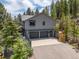 Exterior of home showing garage, driveway, and stairs to separate entrance, highlighting accessibility at 6882 Snowshoe Trl, Evergreen, CO 80439