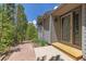 Charming home exterior featuring a stone walkway, lush trees, and a gray facade at 6882 Snowshoe Trl, Evergreen, CO 80439