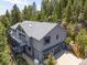Home exterior displaying attached garage, deck, and skylights, harmonizing with the forested setting at 6882 Snowshoe Trl, Evergreen, CO 80439