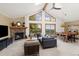 Spacious living room with vaulted ceilings, large windows, and a stone fireplace at 6882 Snowshoe Trl, Evergreen, CO 80439