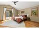 Bright main bedroom featuring hardwood floors, a ceiling fan, and sliding door access to a private deck at 6882 Snowshoe Trl, Evergreen, CO 80439