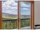 Scenic view from the balcony through a glass door, showcasing mountains and blue skies at 6882 Snowshoe Trl, Evergreen, CO 80439