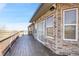 Expansive wood deck with brick home exterior and sliding glass doors at 44000 E 88Th Ave, Bennett, CO 80102