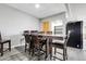 Open-concept dining room with seating for six, gray vinyl floors, modern lighting, and access to a basement area at 44000 E 88Th Ave, Bennett, CO 80102