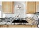 Kitchen sink with stylish countertops, backsplash, and wooden cabinets at 44000 E 88Th Ave, Bennett, CO 80102