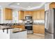 Well-appointed kitchen with stainless steel appliances and plenty of wood cabinetry for storage at 44000 E 88Th Ave, Bennett, CO 80102