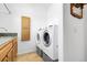 Laundry room featuring matching washer and dryer, tile floor and sink with cabinets at 44000 E 88Th Ave, Bennett, CO 80102