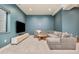 Finished basement lounge area with comfortable sectional couch and mounted TV at 1983 S Logan St, Denver, CO 80210