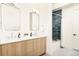 Double vanity bathroom featuring modern finishes, wood grain cabinets, and frameless mirrors at 1983 S Logan St, Denver, CO 80210
