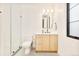 Modern bathroom featuring wood grain cabinets, bright lighting and frameless shower at 1983 S Logan St, Denver, CO 80210