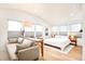 Well-lit main room offers a sitting area, hardwood floors, modern decor, and a queen-sized bed by large windows at 1983 S Logan St, Denver, CO 80210