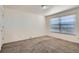 Bright bedroom featuring neutral carpeting, a large window, and ample space for personalization at 4240 S Yukon Way, Lakewood, CO 80235