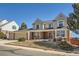Traditional two-story home with a three-car garage and a manicured front yard at 4240 S Yukon Way, Lakewood, CO 80235