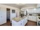 Updated kitchen features white cabinets, stainless steel appliances, and a large island with bar seating at 4240 S Yukon Way, Lakewood, CO 80235