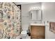 Charming bathroom features a colorful shower curtain, classic vanity, and tiled floors at 1212 S Uvalda St, Aurora, CO 80012