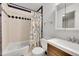Charming bathroom features a tiled shower/tub, colorful shower curtain, and classic vanity at 1212 S Uvalda St, Aurora, CO 80012