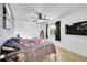 This bedroom features a ceiling fan, TV, and a window with black-out curtains at 1212 S Uvalda St, Aurora, CO 80012