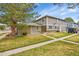 Exterior featuring a well-maintained lawn, mature trees, and the front of the home at 1212 S Uvalda St, Aurora, CO 80012