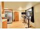 This picture displays the hardwood floors, a fridge, an armoire, and a work desk at 1212 S Uvalda St, Aurora, CO 80012
