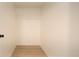 A simple white walk-in closet space with modern wood flooring and basic shelving at 3450 S Poplar St # 307, Denver, CO 80224