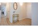 Entryway hallway with light wood floors, mirrored table, and white walls at 3450 S Poplar St # 307, Denver, CO 80224