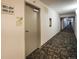 A well-lit hallway with decorative carpeting leads to the apartment units at 3450 S Poplar St # 307, Denver, CO 80224