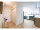 Hallway leading to modern kitchen featuring white cabinets and stainless steel appliances at 3450 S Poplar St # 307, Denver, CO 80224