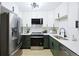 Modern kitchen with stainless steel appliances, stylish lighting, and sleek white cabinets at 3450 S Poplar St # 307, Denver, CO 80224