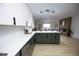 Contemporary kitchen boasts sleek white countertops, two-tone cabinets, and open layout to living space at 3450 S Poplar St # 307, Denver, CO 80224