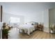 Spacious and bright bedroom with light-colored wood floors, a queen bed, and seating at 3450 S Poplar St # 307, Denver, CO 80224