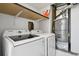 Laundry room featuring white washer and dryer, shelving, and mechanicals at 921 S Zeno Way # 201, Aurora, CO 80017