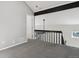 Loft area with gray carpet, beam detail, and railing overlooking the living area at 921 S Zeno Way # 201, Aurora, CO 80017