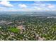 Wide aerial shot showcases residential area, open green spaces, and mountain views at 12625 W 66Th Cir, Arvada, CO 80004