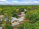 Aerial view features lush trees, rooftops, landscaping, and a mountain backdrop at 12625 W 66Th Cir, Arvada, CO 80004