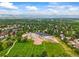Scenic aerial shot showcasing a neighborhood with a school, expansive green spaces, and mountain views in the distance at 12625 W 66Th Cir, Arvada, CO 80004