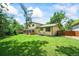 Spacious backyard with lush green lawn, patio, mature trees, and a charming covered outdoor seating area at 12625 W 66Th Cir, Arvada, CO 80004