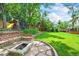 Spacious backyard with a fire pit, play set, and lush lawn at 12625 W 66Th Cir, Arvada, CO 80004
