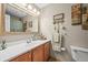 Bright bathroom with a decorative mirror, updated vanity, and modern fixtures at 12625 W 66Th Cir, Arvada, CO 80004