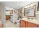 Neutral bathroom with a decorative mirror, a wooden vanity and an adjacent laundry area at 12625 W 66Th Cir, Arvada, CO 80004