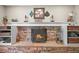 Inviting fireplace with brick surround, custom mantle, and decorative hearth accents at 12625 W 66Th Cir, Arvada, CO 80004