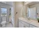 Well-lit bathroom with a single vanity, toilet, and tub/shower combination with a decorative shower curtain at 23957 E Rocky Top Ave, Aurora, CO 80016