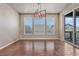 Dining area with hardwood flooring, modern chandelier, and sliding glass doors leading to the outdoor living space at 23957 E Rocky Top Ave, Aurora, CO 80016