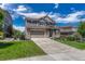 Charming two-story home with a stone facade and well-manicured front lawn under a bright blue, cloudy sky at 23957 E Rocky Top Ave, Aurora, CO 80016