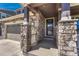 Inviting front porch with stone columns, decorative railing, and front door at 23957 E Rocky Top Ave, Aurora, CO 80016