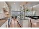 Bright kitchen with an island and stainless steel appliances opens up to a dining area and living space at 23957 E Rocky Top Ave, Aurora, CO 80016