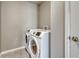 Compact laundry room with white, front-load washer and dryer units at 23957 E Rocky Top Ave, Aurora, CO 80016