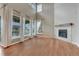 Bright living room with hardwood floors, high ceilings, large windows, and a fireplace with a wooden mantel at 23957 E Rocky Top Ave, Aurora, CO 80016